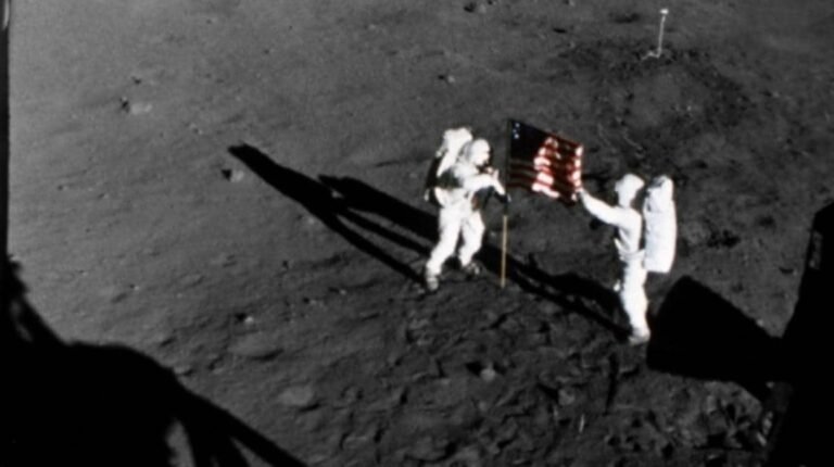 astronauta plantando bandera en la luna