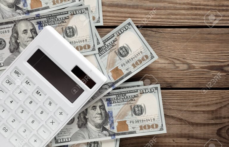 calculadora y billetes sobre una mesa