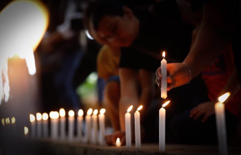 gente con velas en un memorial