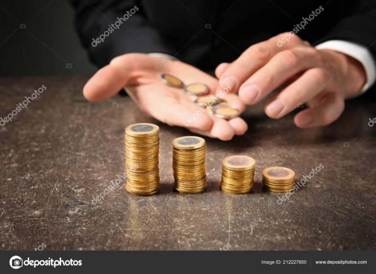 manos contando monedas sobre una mesa