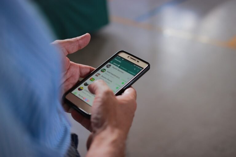manos usando un telefono movil con whatsapp