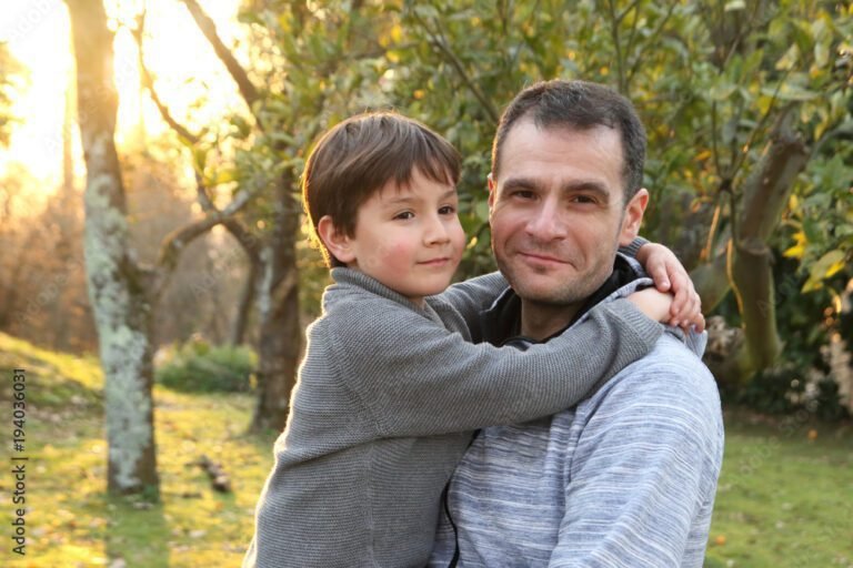 padres abrazados con fotos de su hijo