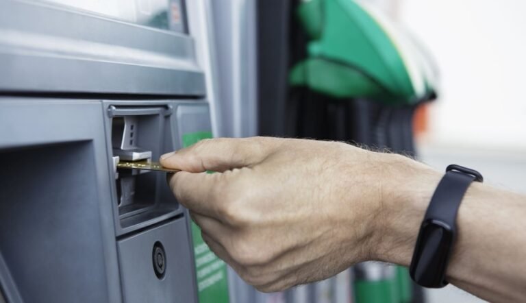 tarjeta de credito en mano repostando gasolina